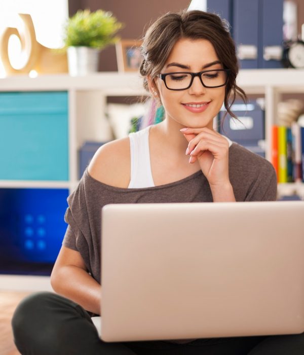 mujer-sonriente-usando-computadora-portatil-suelo-su-casa_329181-4273